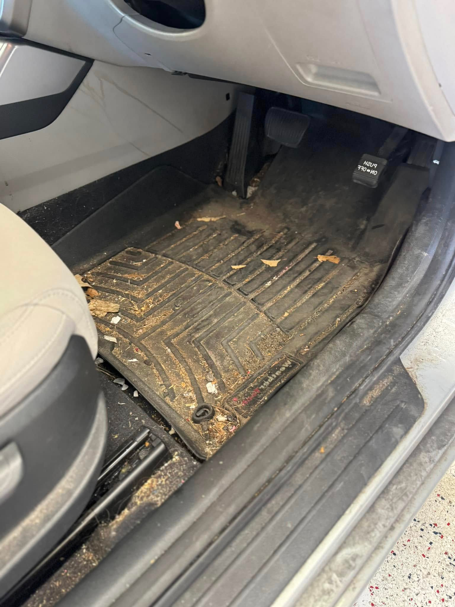 The before photo of the dirty floor mats of a vehicle before a car detailing appointment at Clean Car Wash and Detail in Fredericksburg, VA.